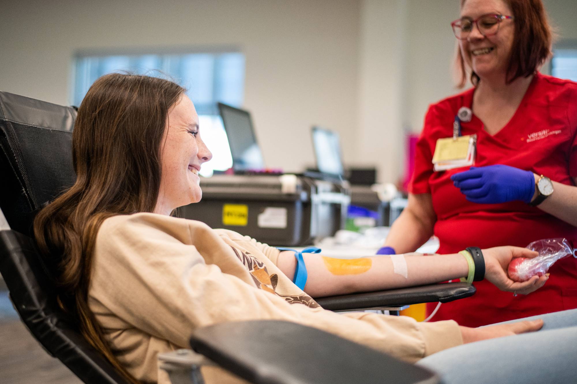 A student smiling with their arm out, waiting for their blood to be drawn